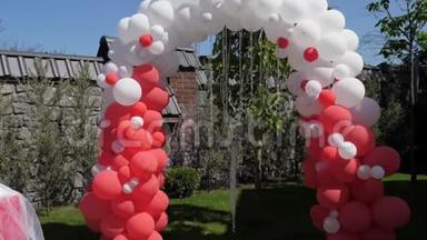 婚礼拱门由红<strong>白气球</strong>制成，婚礼仪式，绿色草坪。
